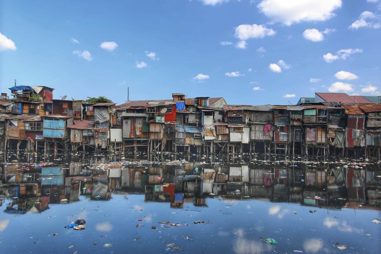 Shacks and shanties provide some of the more stable forms of housing in Manila's slums. With steady typhoons and rising sea levels, some residents have built their dwellings on stilts, avoiding the flooding that besets those on lower ground. Scavengers float atop the filthy rover collecting any items of value.
